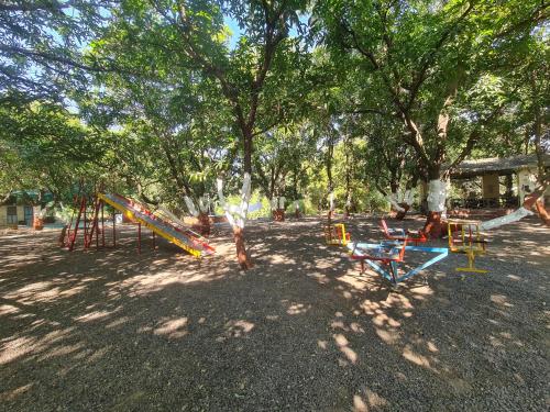 a park with a playground with slides and trees at The Wilds Villa Gir Jungle Stay with Swimming Pool in Sasan Gir