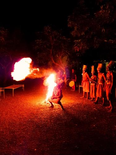a group of people standing around a fire at The Wilds Villa Gir Jungle Stay with Swimming Pool in Sasan Gir