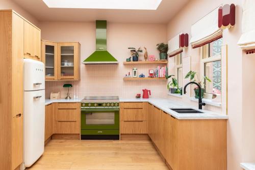 a kitchen with wooden cabinets and green appliances at Luxurious and Bright Dublin Home in Dublin