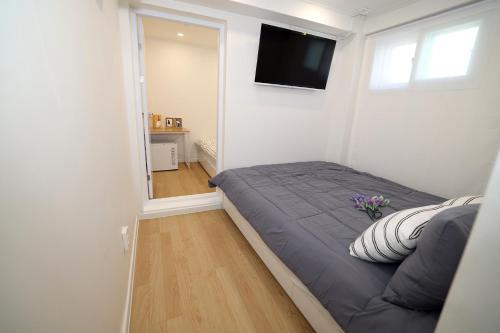 a bedroom with a bed and a television on a wall at Stay107 in Seoul