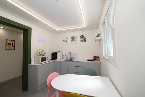 a kitchen with a white table and a white counter top at Stay107 in Seoul