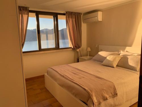 a bedroom with a bed with a large window at Suite Incanto lago di Garda in Torri del Benaco