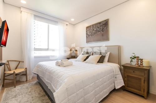 ein weißes Schlafzimmer mit einem Bett und einem Fenster in der Unterkunft Elegant 2 Bed Apt In The Center Of Villa Morra in Asunción