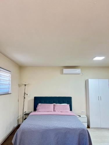 a bedroom with a large bed with pink pillows at Guest House Bosnian House in Sarajevo