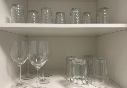 a bunch of wine glasses sitting on a shelf at Spacious Apartment with Balcony - nearby Schlosspark - APOLONIAliving in Karlsruhe
