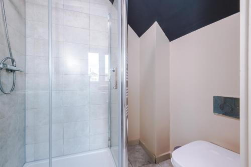 a bathroom with a shower and a white toilet at Modern 2BR near Wigan Town Centre in Wigan