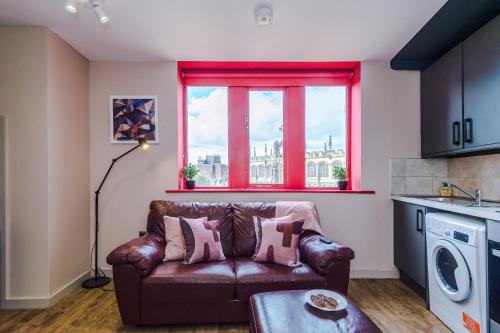 a living room with a leather couch and a window at Modern 2BR near Wigan Town Centre in Wigan