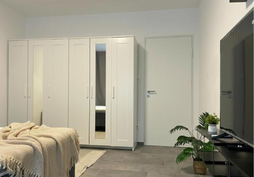 a bedroom with white cabinets and a bed and a tv at Spacious Apartment with Balcony - nearby Schlosspark - APOLONIAliving in Karlsruhe