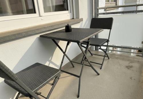 a table and two chairs next to a window at Spacious Apartment with Balcony - nearby Schlosspark - APOLONIAliving in Karlsruhe