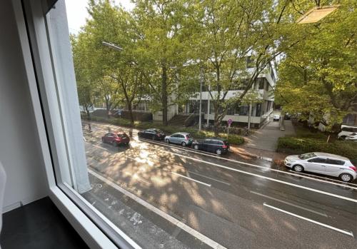 a view from a window of cars parked on a street at Spacious Apartment with Balcony - nearby Schlosspark - APOLONIAliving in Karlsruhe
