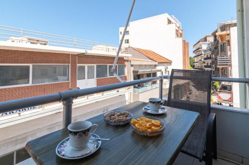 Una mesa en un balcón con dos tazas de café y galletas. en Alena Apartments, en La Canea