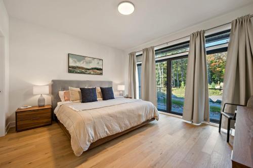 モントランブランにあるTremblant Prestige - Verbier 13-101のベッドと大きな窓のある寝室
