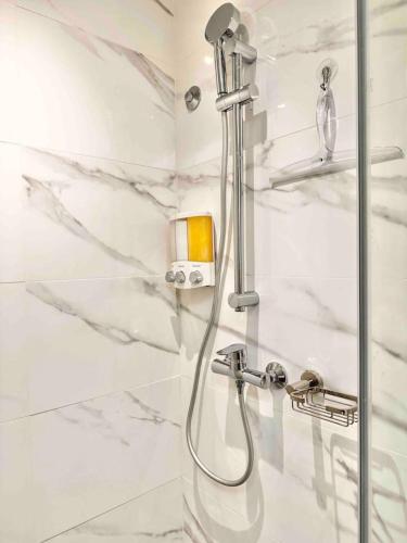 a bathroom with a shower with white marble walls at Stylish Upscale Condo, Pool in Santo Domingo