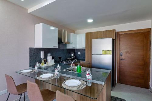a kitchen with a counter with chairs and a refrigerator at Comfy 1BR Centric Apt King Bed in La Julia