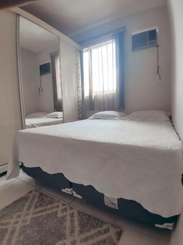 a bedroom with a large bed in front of a mirror at Apartamento cop 30 in Marituba