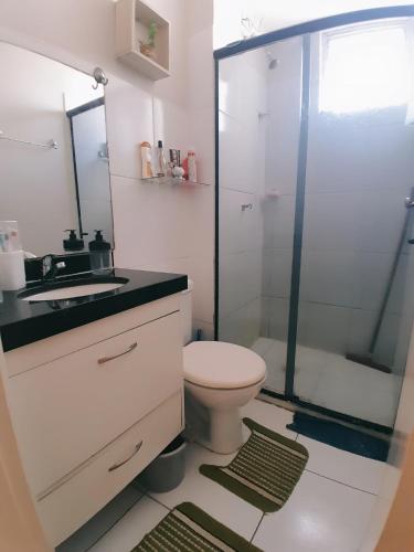 a bathroom with a toilet and a glass shower at Apartamento cop 30 in Marituba