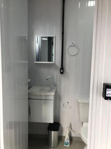 un bagno bianco con lavandino e WC di Kitnet Nova e Aconchegante a Cachoeira do Sul