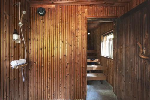 a bathroom with a wooden wall with a sink at Stay North - Veteran's House in Kiljava