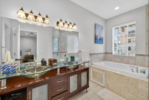 a bathroom with two sinks and a bath tub at Daisy Elegance Townhouse Steps from The Beach in Pompano Beach