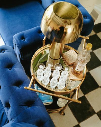 a gold end table with glass bottles and a lamp at Ca Sana Teulada Moraira, Grupo Terra de Mar, alojamientos con encanto in Moraira