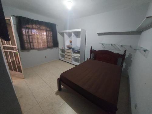 een slaapkamer met een bed en een koelkast bij Piscina e mar in Angra dos Reis