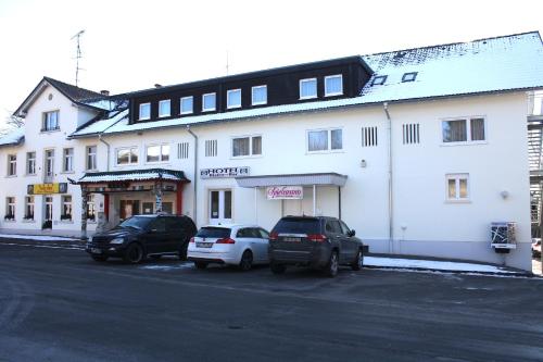 two cars parked in front of a white building at Hotel Bahnhof Jestetten in Jestetten