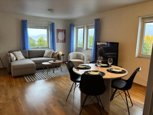 a living room with a table and a couch at HB HolidayHomes - The White Pearl in Tromsø