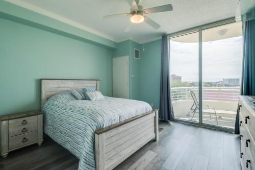 a bedroom with a bed with a ceiling fan and a balcony at The Driftwood Oasis in Biloxi