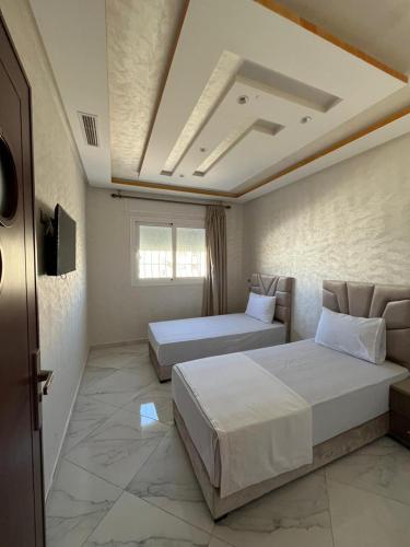 a hotel room with two beds and a tv at Luxe app 2 chambres in Tangier