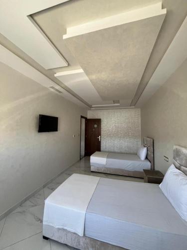 a hotel room with two beds and a tv at Luxe app 2 chambres in Tangier