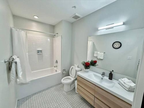 a white bathroom with a toilet and a sink at Verdant Luxe Studio in Des Moines