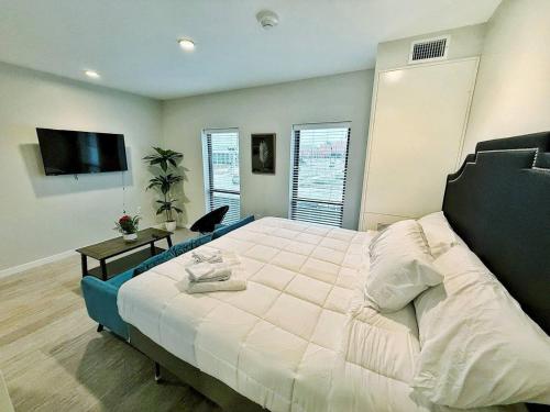 a bedroom with a large bed and a flat screen tv at Verdant Luxe Studio in Des Moines