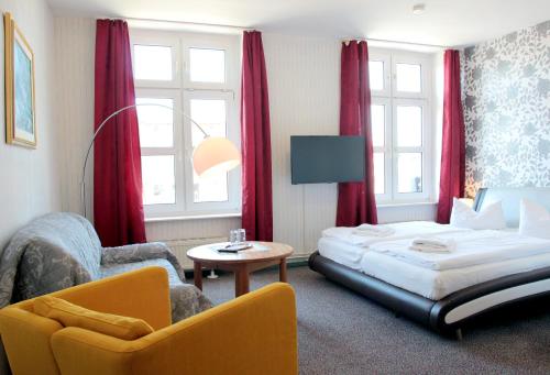 a hotel room with a bed and a chair at Pension Klabautermann in Stralsund