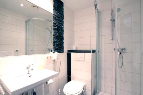 ein Bad mit einem WC, einem Waschbecken und einer Dusche in der Unterkunft Pension Klabautermann in Stralsund