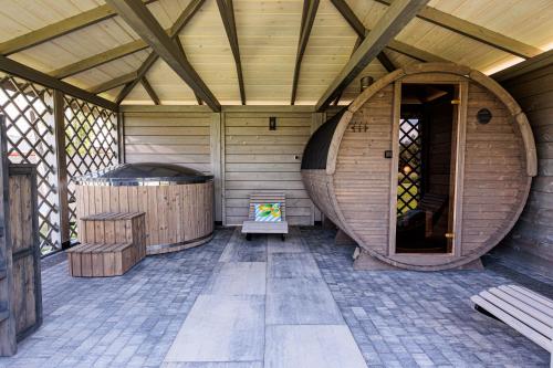 an inside of a wooden building with a hot tub at Podlaskie Chatki Ciszą Malowane - Domek nr 2 in Krynki