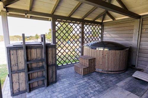 an outdoor deck with a hot tub and a grill at Podlaskie Chatki Ciszą Malowane - Domek nr 2 in Krynki