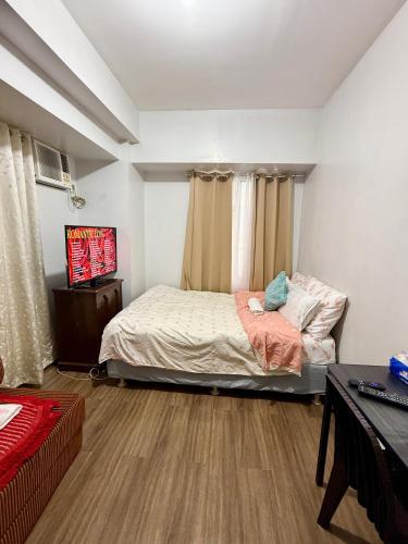 a bedroom with a bed and a television in it at 1BR LaVerti Cloud Nine Suite Family Affordable Staycation in Manila
