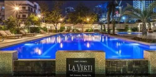 a large swimming pool with blue water at night at 1BR LaVerti Cloud Nine Suite Family Affordable Staycation in Manila