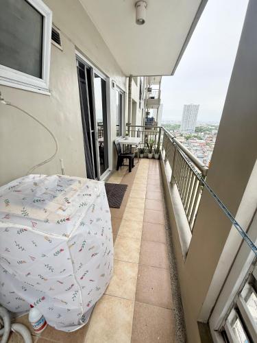 a balcony with a table and an umbrella at 1BR LaVerti Cloud Nine Suite Family Affordable Staycation in Manila