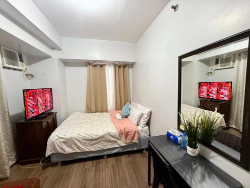 a bedroom with a bed and a large mirror at 1BR LaVerti Cloud Nine Suite Family Affordable Staycation in Manila