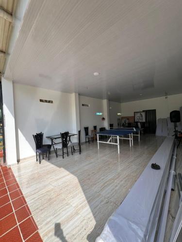 a room with a ping pong table and chairs at Hotel Yamboró in Pitalito
