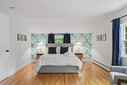 a white bedroom with a bed and a chair at Stylish Stoneham Getaway Playground Game Room in Stoneham