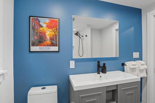 a bathroom with a white sink and a blue wall at Stylish Stoneham Getaway Playground Game Room in Stoneham