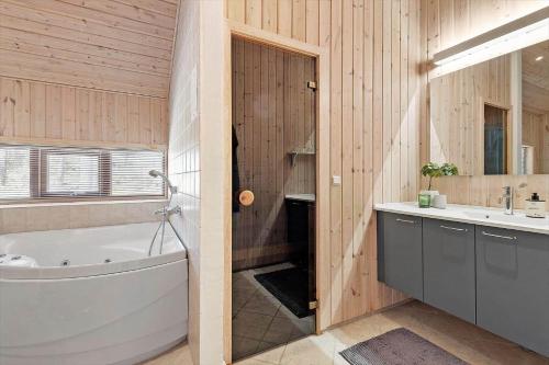 ein Badezimmer mit Badewanne und Waschbecken in der Unterkunft 2706 Nexø - Harevej 11 in Neksø