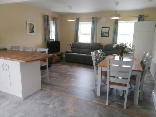 a kitchen and living room with a table and a couch at Loophead SelfCatering Cottage SensoryAccessible in Kilrush