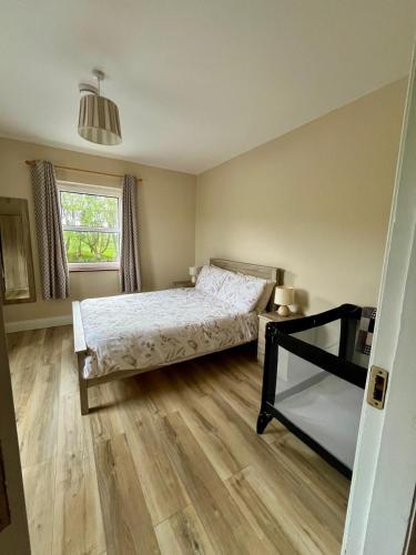 a bedroom with a bed and a window at Loophead Self Catering Cottage in Kilrush