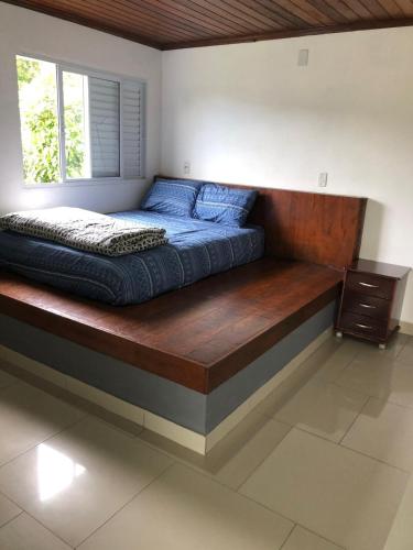 a bed with a wooden platform in a bedroom at Tranquilidade e Ótima localização in São José