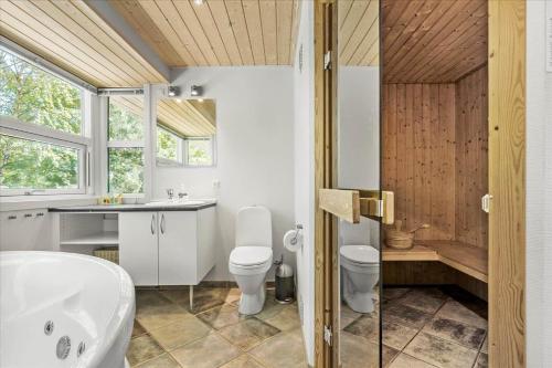 a bathroom with a tub and a toilet and a sink at 1465 Aakirkeby - Poseregårdsvejen 5 in Vester Sømarken