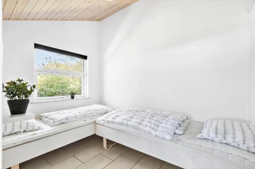 a white room with a bed and a window at 6824 Allinge - Hammervænget 4 in Allinge