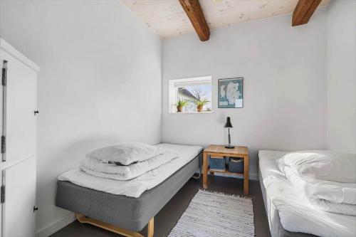 1 dormitorio con 2 camas individuales y mesa en 5638 Svaneke - Oksemyrevejen 2 B, en Svaneke